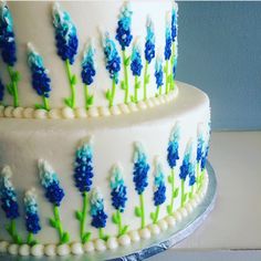 two tiered cake decorated with blue and green flowers