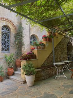 an outdoor patio with potted plants and tables