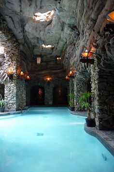 an indoor swimming pool surrounded by stone walls