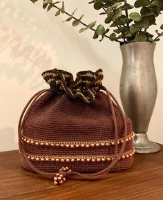 1950s Crocheted Drawstring Purse, 50s Handbag, Mid Century Accessory  Unique 50s brown, gold and black crocheted drawstring purse. It has a brown gimp cord crocheted body with crocheted black and metallic gold crocheted around the top of the bag. Metallic gold with decorative copper plastic beads trim around the bottom portion of the bag. It has a heavy corded drawstring with decorative cooper bead accents. Opens to a satin lining with one interior side open pocket.  The satin covers a sturdy hard plastic half way down the bag. This structure helps the bag sit upright. Mint condition! Measurements: Width x 7.5" across the bottom  Depth x 3.5" across the bottom  Height w/o string handles x 7.5" Mid Century Accessories, Crochet Bodies, Drawstring Purse, Mid Century Mod, Chapel Hill, Beaded Trim, Black Crochet, Plastic Beads, Accessories Unique