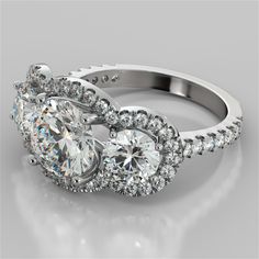 three stone engagement ring with diamond accents on the sides and an oval shaped center surrounded by smaller round diamonds