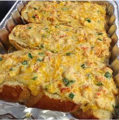 two pieces of bread with cheese and vegetables on them in tin foil lined baking pans