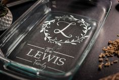 a glass tray with a monogrammed logo on it next to some spices and spoons