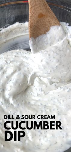 a wooden spoon in a bowl filled with cream and cucumber dip recipe ingredients