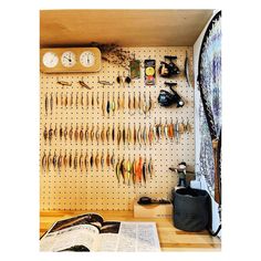 there are many different things on the pegboard in this room, including fishing lures