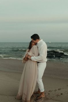 a man and woman kissing on the beach