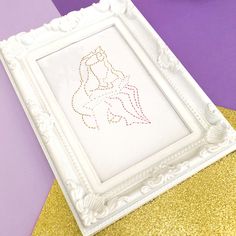 a white frame sitting on top of a table next to a purple and yellow wall