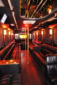 the inside of a bus with black leather seats and lights on it's ceiling