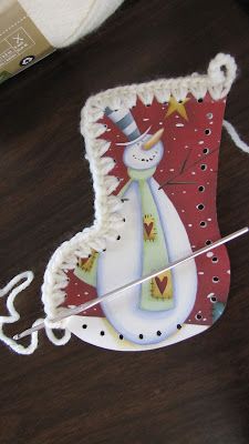 a christmas stocking shaped like a snowman on top of a wooden table with scissors