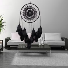 a living room filled with furniture and a large black dream catcher hanging from the ceiling