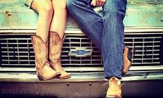 two people sitting on the hood of a car with their legs crossed and cowboy boots hanging out