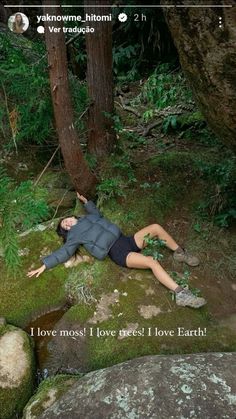 a woman laying on the ground next to a tree and moss covered rocks with words written below