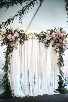 a white drape covered with flowers and greenery