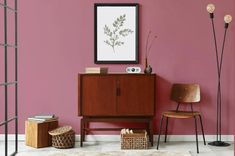 a living room with pink walls and wooden furniture in the corner, along with two floor lamps