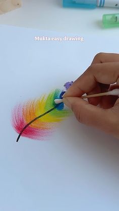 someone is drawing with colored pencils on paper