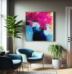 two chairs and a potted plant sit in front of a painting on the wall