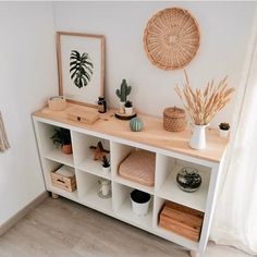 a white shelf with plants and other items on it