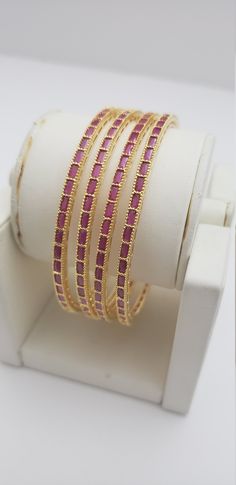 "* Handcrafted Gold Plated 4 Bangle Set. Sold as a set. * Bangles with high quality semi precious ruby stones. * High Quality 22K Gold Plated. Bangles Sizes : 2.4 inches= ( 2.25\" diameter of the inner circle) ; 2.6 inches = ( 2.42\" diameter of the inner circle); 2.8inches = (2.57\" diameter of the inner circle) The gorgeous gold-plated bangles set best exemplifies the careful craftsmanship done on it -- specially picked for you by Nemali Jewelry. It has a special tone of elegance attached to i Adjustable Gold Bracelet With Meenakari, Adjustable Gold Meenakari Bangle, Adjustable Gold Bracelets With Meenakari, Wedding Bangles, Ruby Bangles, The Inner Circle, Kundan Bangles, Glass Bangles, Bangles Set