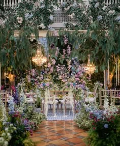 an outdoor dining area decorated with flowers and greenery