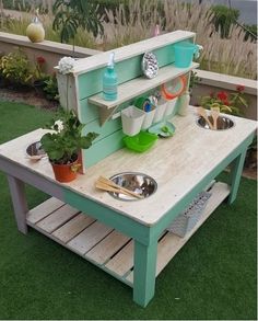 an outdoor play kitchen made out of pallets and wooden crates with plants on top