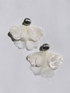 Alina Flower Petal earrings is another signature piece in the Jänkälä collection. 100-year-old Japanese satin flower petals are paired with vintage metal clip-ons. The union of the delicate and the hardy creates a boldly elegant statement piece that will garner attention wherever you go. The earring length is 4.5 inches and clip-ons are 28mm wide. Lovingly handmade by Karo at her home studio in Los Angeles. Handle with care and be kind to yourself. Elegant Clip-on Flower-shaped Earrings, Elegant Clip-on Flower Shaped Earrings, White Clip-on Flower Earrings, White Flower Clip-on Earrings, Handmade Petal Shaped Elegant Earrings, Elegant Handmade Petal Earrings, Elegant Handmade Petal-shaped Earrings, Elegant Clip-on Drop Flower Earrings, White Flower Earrings For Evening