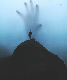 a person standing on top of a mountain in the fog