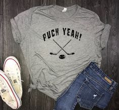 a t - shirt that says puck yeah and two crossed hockey sticks