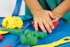 a child's hands on top of play dough