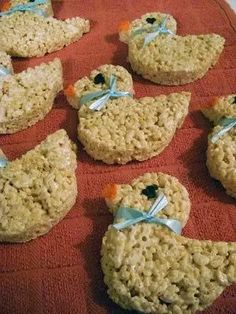 rice krispy treats shaped like birds with bows on them sitting on a red towel