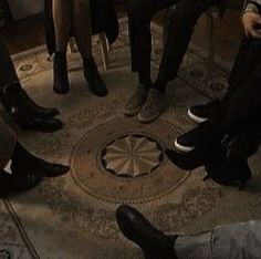 four people sitting in a circle with their feet on each other's legs and one person holding a cell phone