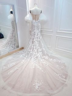 a wedding dress on display in front of a mirror