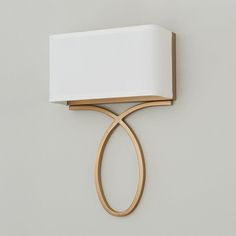 a wall light with a white shade on it's side and a wooden frame