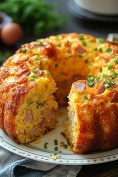 a ham and cheese bundt cake on a white plate with one slice cut out