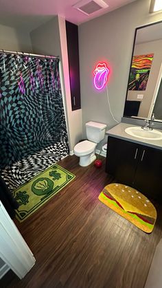 a bathroom with a toilet, sink and shower curtain in it's center area