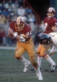 two football players are running on the field