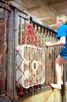 a woman climbing up the side of a metal fence