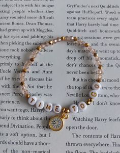 a beaded bracelet with the word time to go written in gold and white beads