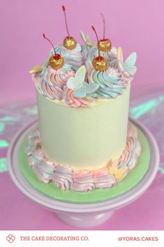 a cake decorated with frosting and cherries on a plate in front of a pink background