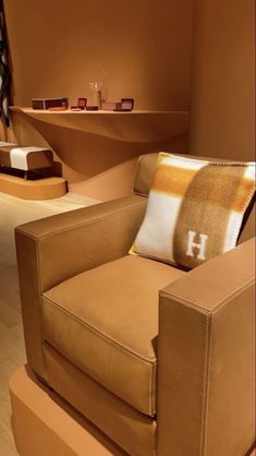 a brown chair sitting on top of a hard wood floor next to a shelf filled with items