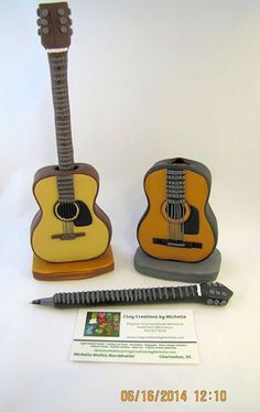 an acoustic guitar and pen holder are on display