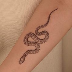 a woman's arm with a snake tattoo on it