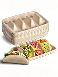 three tacos and two burritos on a white background with an egg tray