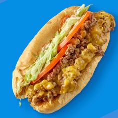 a close up of a sandwich with meat and vegetables in it on a blue background