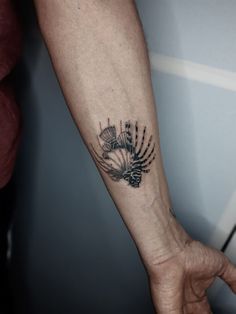 a person's arm with a black and white tattoo design on the left forearm