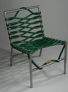 a green chair sitting on top of a white floor next to a metal frame structure