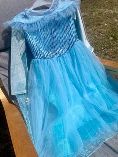 a blue dress sitting on top of a wooden bench