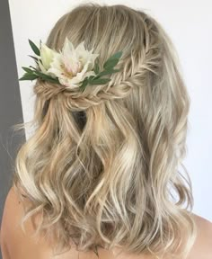 a woman with blonde hair wearing a flower in her hair