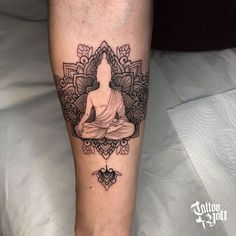 a woman's leg with a tattoo on it and a buddha sitting in the middle