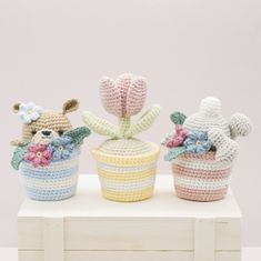 three small crocheted baskets with stuffed animals in them