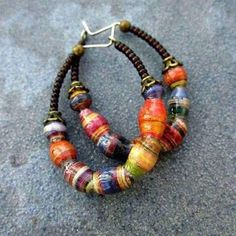 two bracelets made out of paper and beads on the ground next to each other